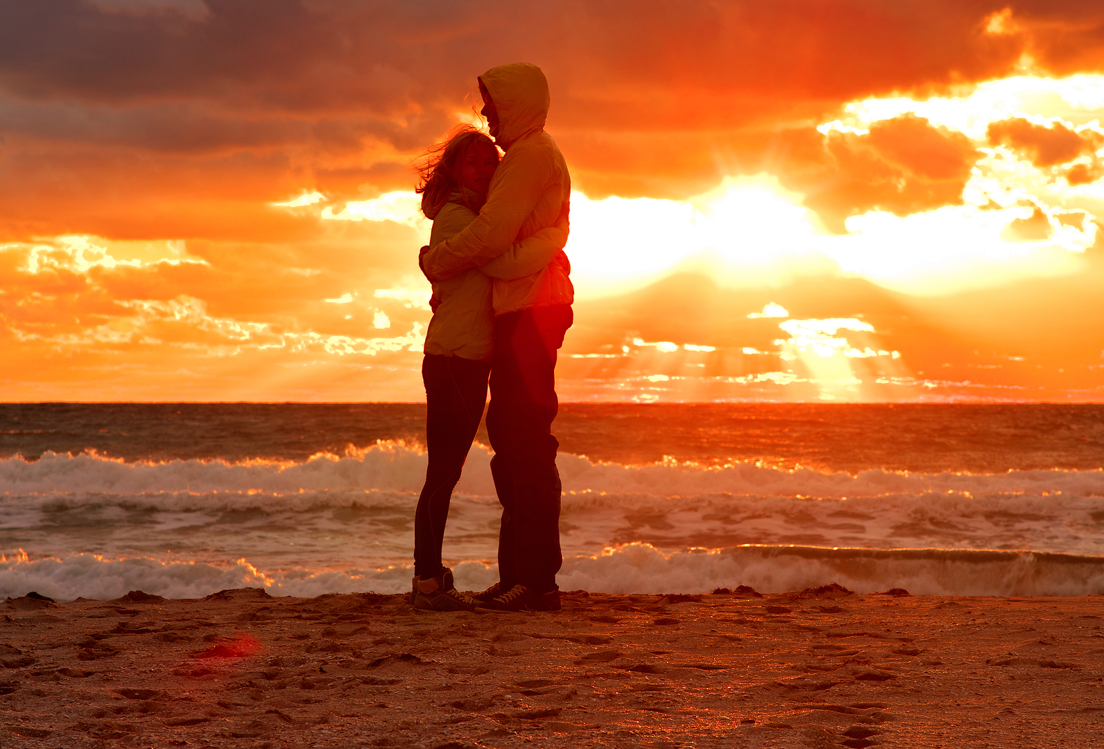Мужчина и женщина обнимаются на закате